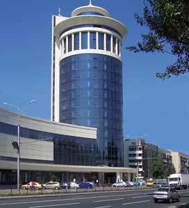 Бизнес-центр в виде башни, пристроенной к круглому зданию.